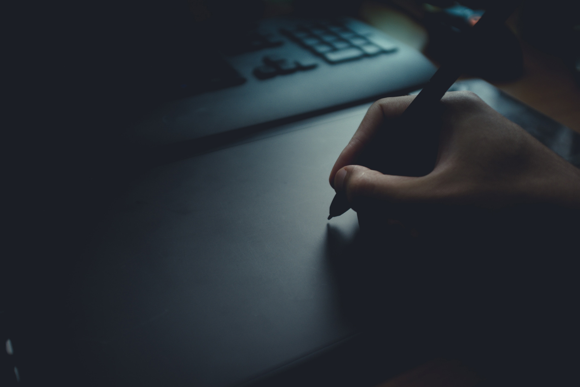 Hand schreibt digital auf einem Tablet – Symbolisierung der Trauerarbeit in der digitalen Welt.