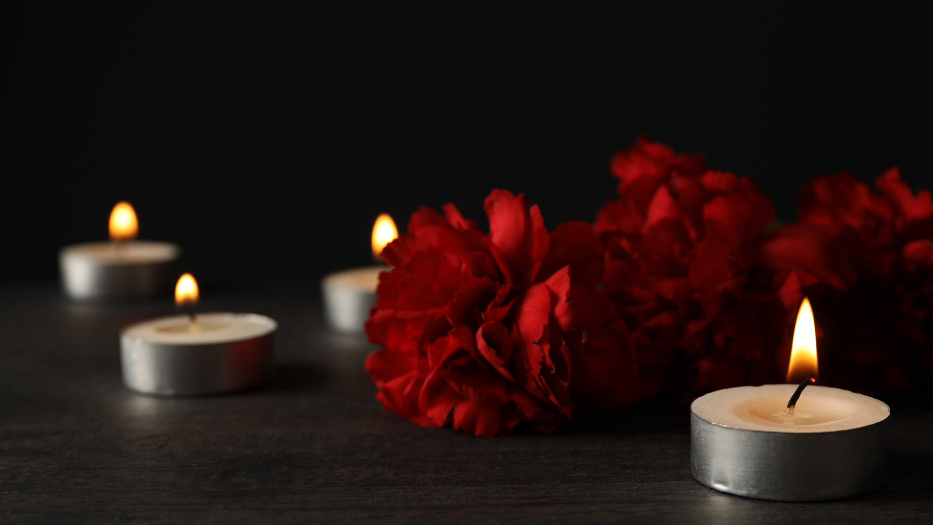 Teelichter und rote Blumen – Symbole für verschiedene Bestattungsarten und Abschiedsrituale